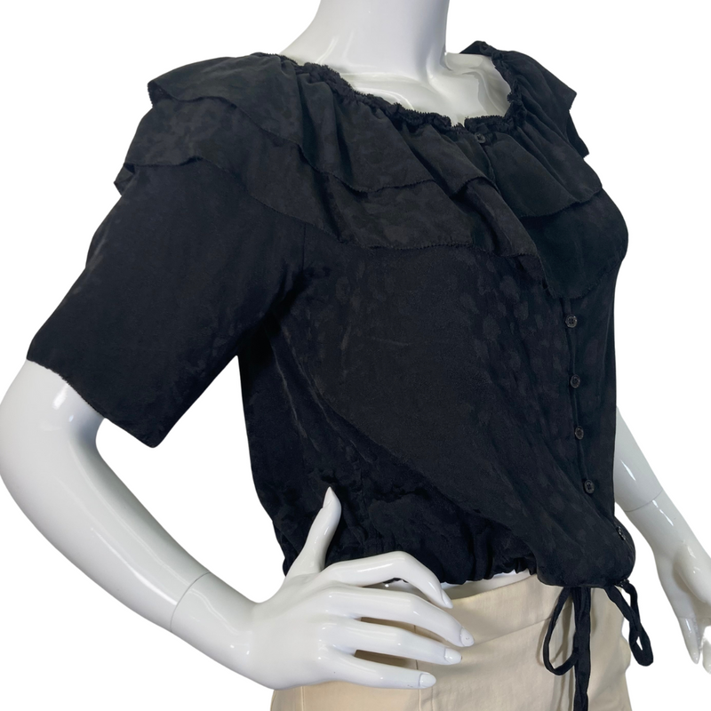 Load image into Gallery viewer, This pre-loved Zadig &amp; Voltaire Black Ruffle Blouse is a vintage-inspired short-sleeve blouse with layered ruffle details along the neckline, button-down front, and an adjustable drawstring waist for a flattering fit - side view
